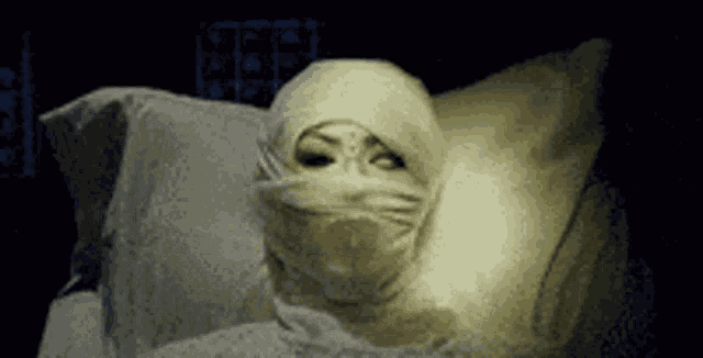 a woman is laying in a bed with a bandage on her face .