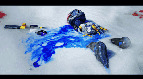 a person is laying in the snow with a blue liquid coming out of their body