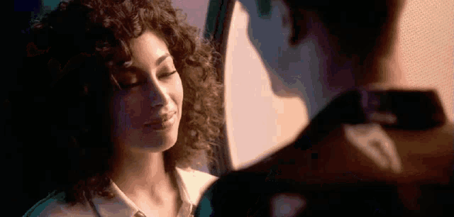 a man and a woman are looking at each other in a mirror .