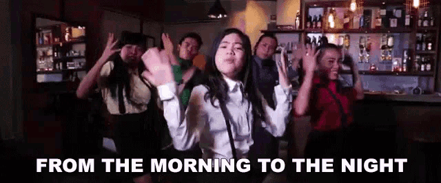 a group of people dancing in a bar with the words from the morning to the night