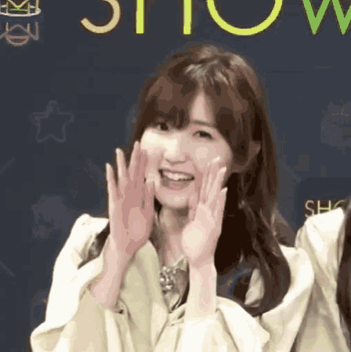 a girl with her hands on her face in front of a show sign