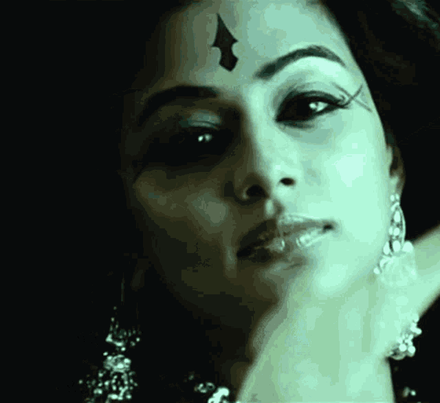 a close up of a woman 's face with an arrow on her forehead