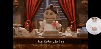 a doll is sitting at a desk with arabic writing