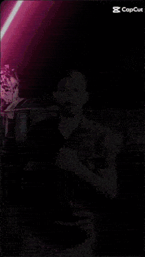 a man is standing in front of a purple light that says capcut on the bottom right