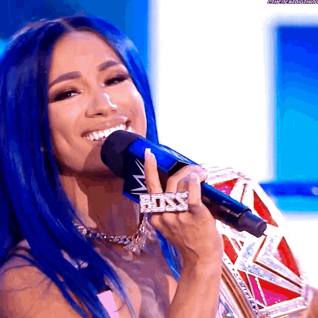 a woman with blue hair is singing into a microphone with a ring that says boss