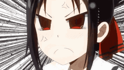 a close up of a girl with a red bow on her head making an angry face .