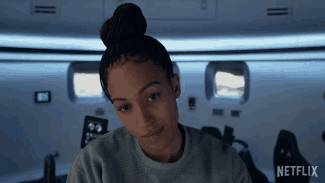 a woman in a gray sweater with the word netflix on the bottom right