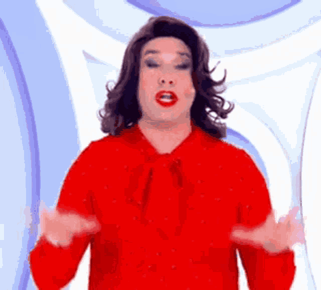 a man in a red shirt is making a face