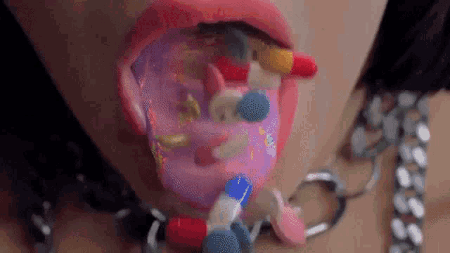 a close up of a woman 's mouth with pills and a donut on her tongue .