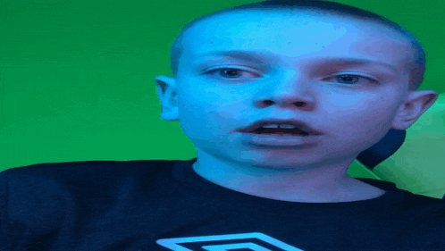 a young boy is wearing a black shirt with a white umbro logo on the front