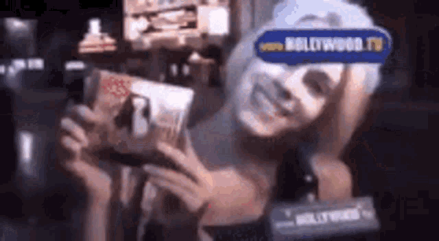 a woman wearing a mask is holding a bag of chips and smiling .