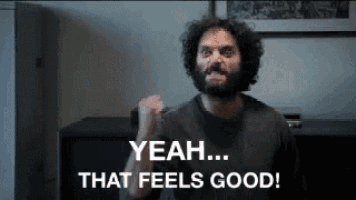 a man with a beard is making a fist and says yeah that feels good