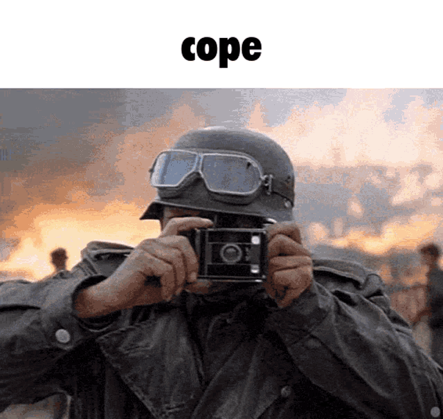 a man wearing a helmet and goggles is taking a picture with a camera and the word cope above him