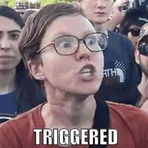 a woman wearing glasses and a red shirt is making a funny face in front of a crowd of people .
