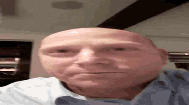 a close up of a bald man 's face with his eyes closed