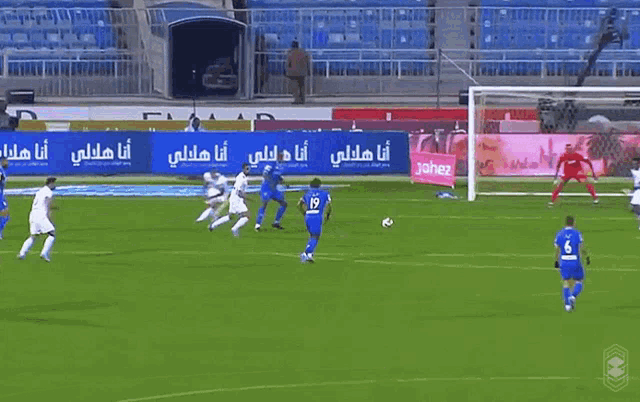 soccer players on a field with a sign that says emaar