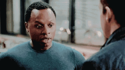 a man in a blue sweater is talking to another man .