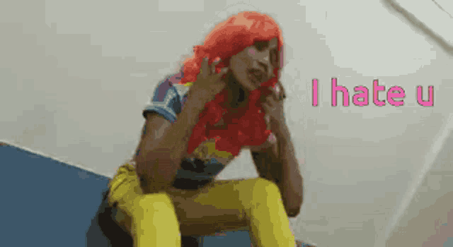 a woman in a red wig is sitting on a staircase with the words `` i hate u '' behind her .