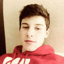 a young man wearing a red hoodie with the word cali on it