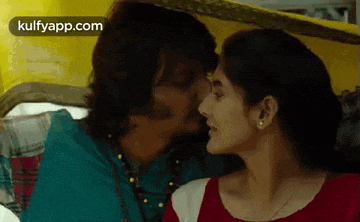 a man and a woman are kissing under an umbrella in a car .