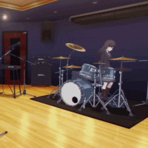 a girl playing drums in a room with a drum set