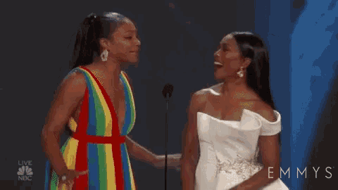 two women are standing next to each other in front of a microphone .
