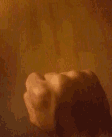 a close up of a person 's middle finger against a brown background
