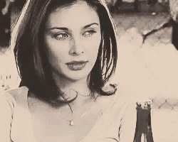 a black and white photo of a woman wearing a white shirt and a necklace .
