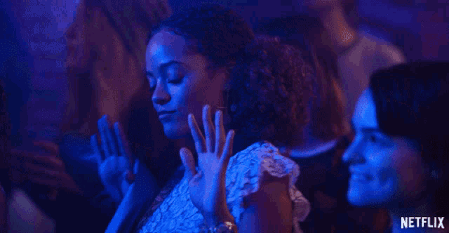 a group of people are dancing in a dark room with a netflix logo in the corner