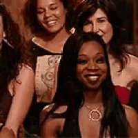 a group of women are posing for a picture and one of them is wearing a necklace