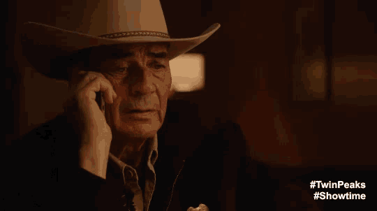a man in a cowboy hat talking on a phone