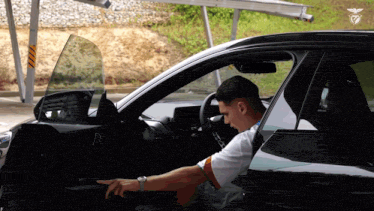 a man is sitting in a car with the letter d on the side