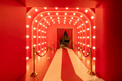 a red and white striped carpeted hallway with a red curtain and lights