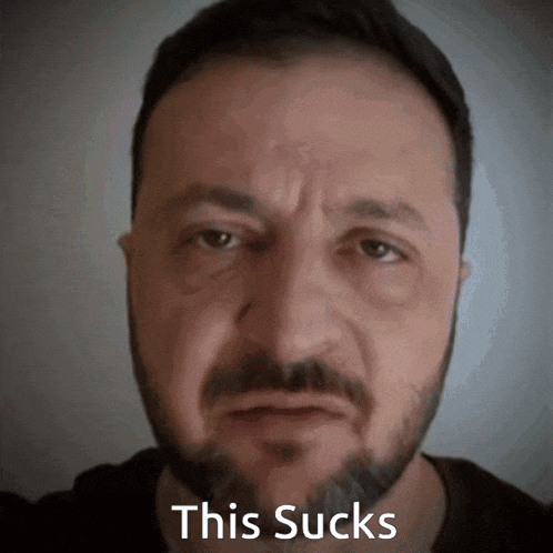 a man with a beard has the words this sucks written on his face