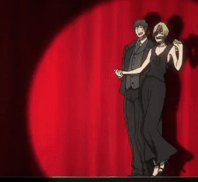 a man and a woman are dancing on a stage with a red curtain in the background .
