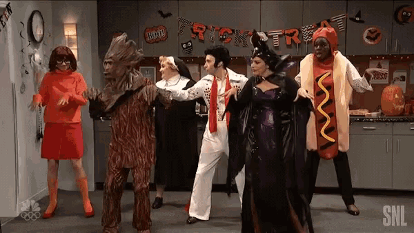 a group of people in costumes are dancing in front of a trick or treat banner