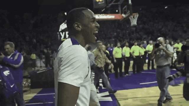a basketball player wearing a k-state jersey celebrates