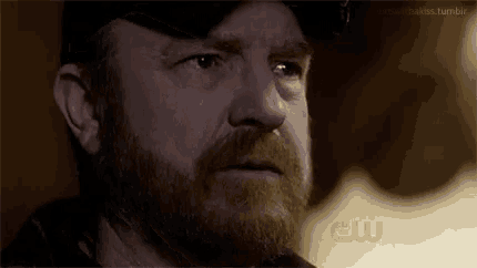 a close up of a man 's face with a cw logo on the bottom right