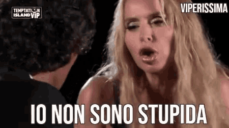 a woman is making a funny face while talking to a man and says `` io non sono stupida '' .