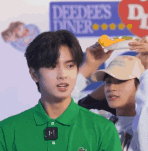 a man in a green shirt stands in front of a sign for deedees diner
