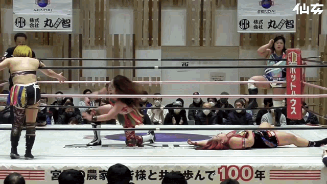 two women are wrestling in a ring with a sign that says 100 on it