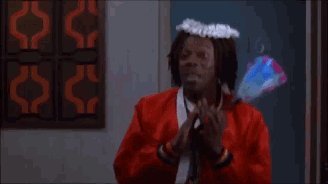 a man in a red jacket is holding a flower and says c'est la femme de ménage