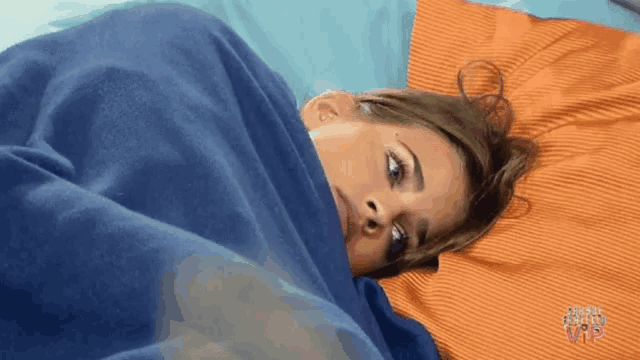 a woman is laying in bed under a blue blanket with the word vip on it