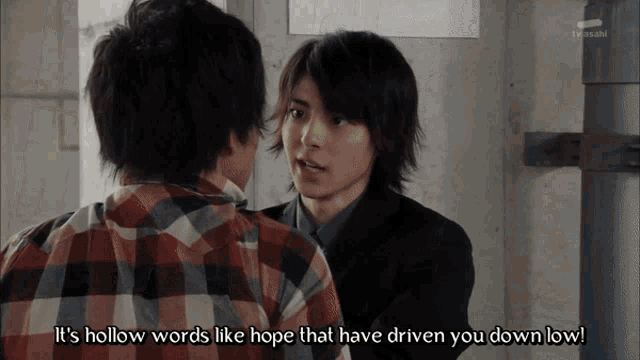 a man in a plaid shirt is talking to another man in a black suit