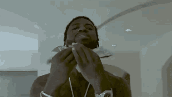 a man is holding a bunch of money in his hands and eating it .
