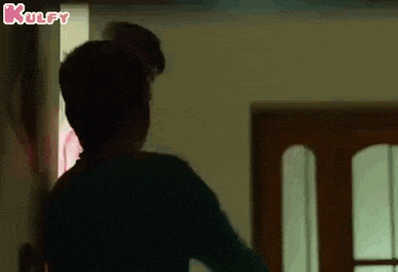 a man is standing in a dark room next to a door .