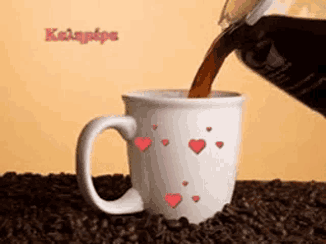 a cup of coffee is being poured into a mug with hearts on it