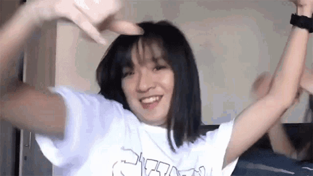 a woman is dancing with her arms in the air and smiling .