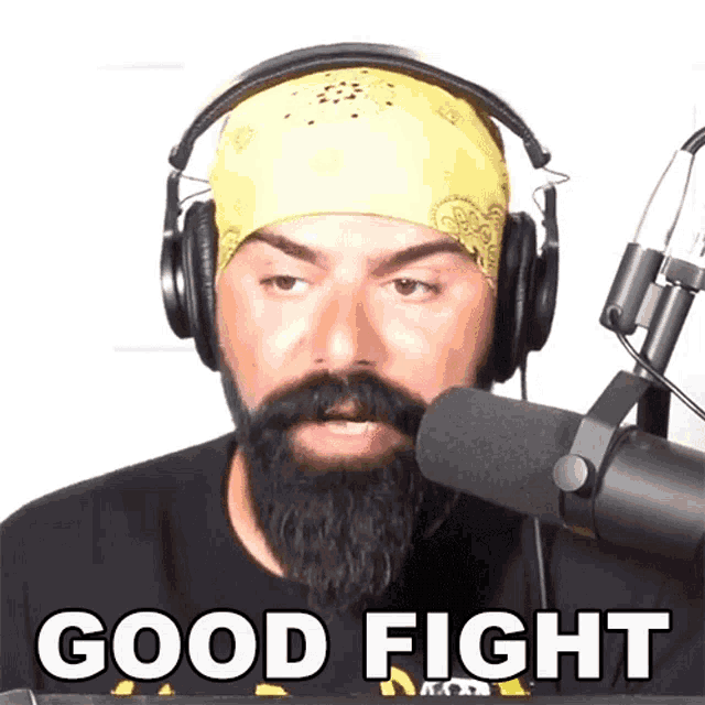 a man with a beard wearing headphones and a bandana says " good fight "