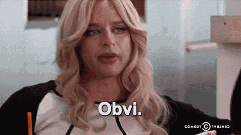 a woman in a wig is saying obvi while holding a pencil in her hand .
